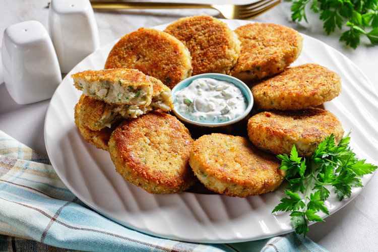 Fischfrikadellen mit Tsatsiki auf einem Teller