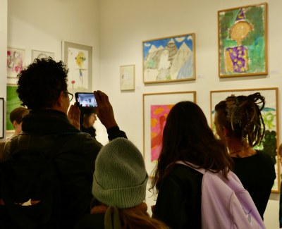 Besucher*innen fotografieren die Ausstellung